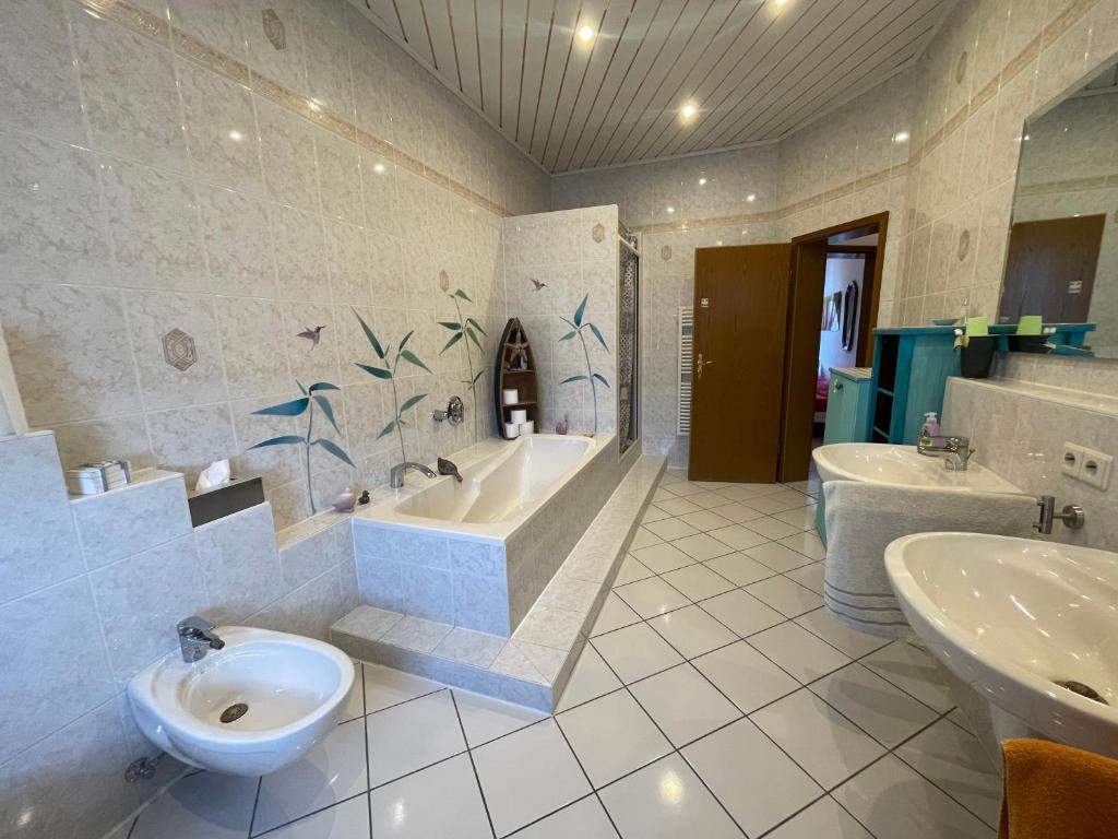 Attraktive 2 Zimmer Wohnung in Toplage, Nähe Messe في هانوفر: حمام به مغسلتين وحوض استحمام ومرحاض