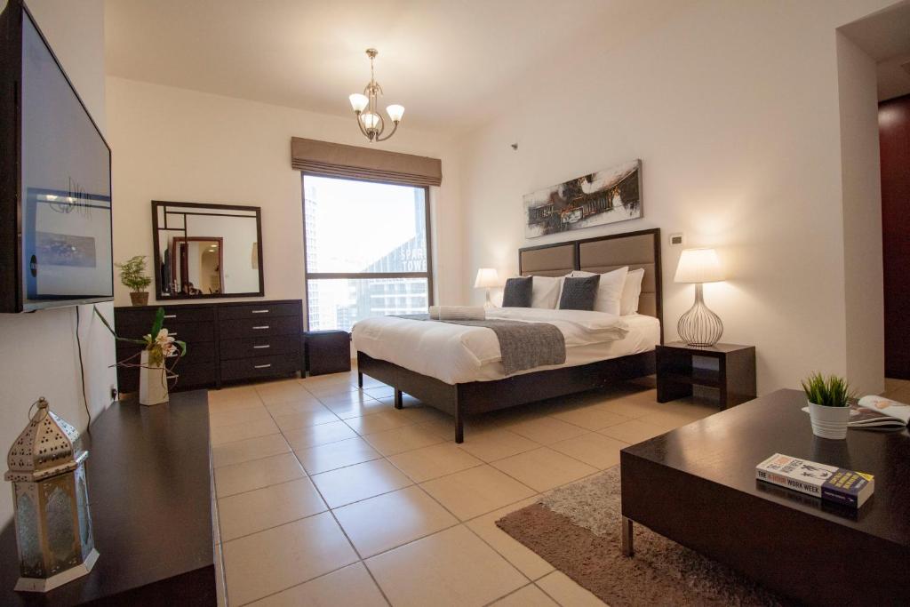 - une grande chambre avec un lit et une grande fenêtre dans l'établissement Modern, Luxe & Spacious 4-Bed Condo, Full Kitchen, 3 Min walk to Beach, Tram & Marina By "La Buena Vida Holiday Homes", à Dubaï