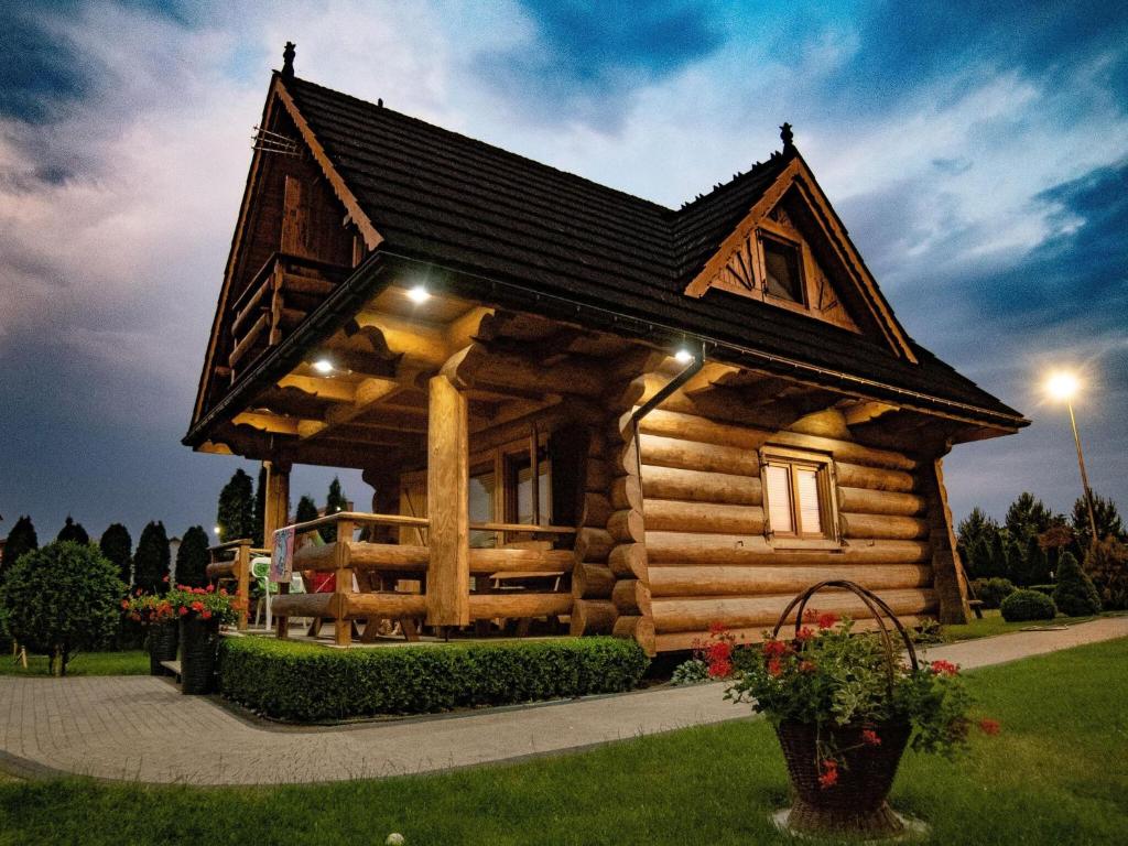 a log cabin house with lights on it at Holiday resort, Wicie in Wicie