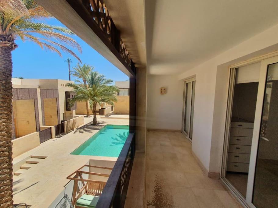a house with a swimming pool and a palm tree at Nayah Stays, Beautiful 3-bedroom vacation home with lovely pool in Hurghada