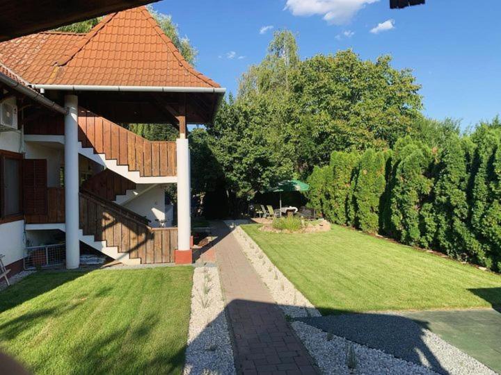 uma casa com um jardim relvado com um edifício em Napsütötte Kehida em Kehidakustány