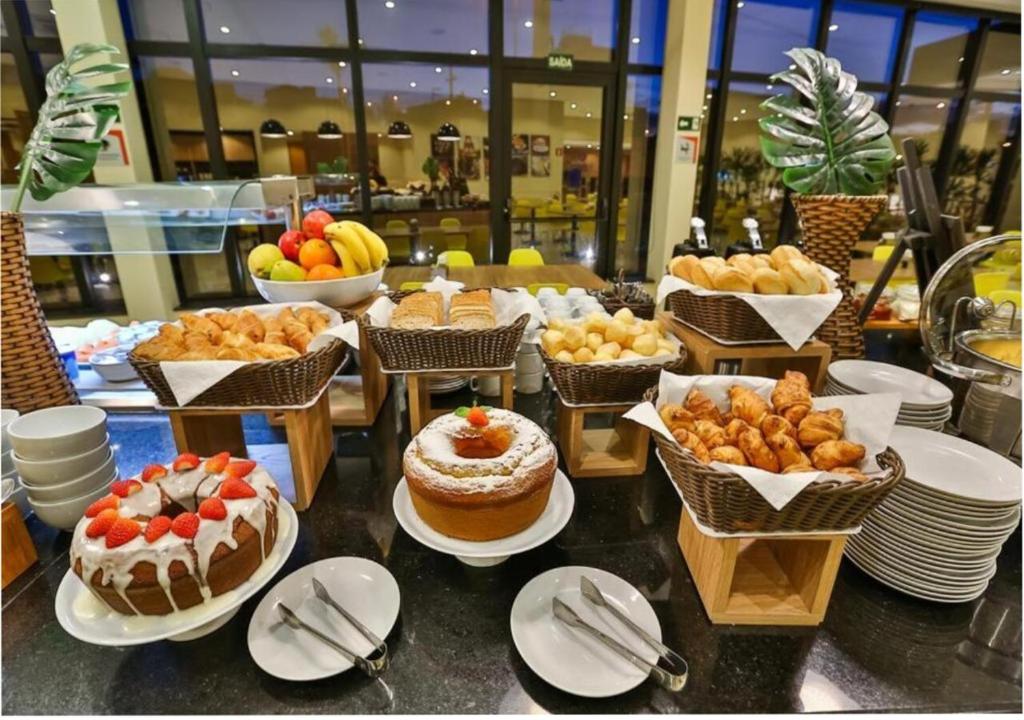 a buffet with many different types of cakes and pastries at Transamerica Fit Jaguariúna in Jaguariúna