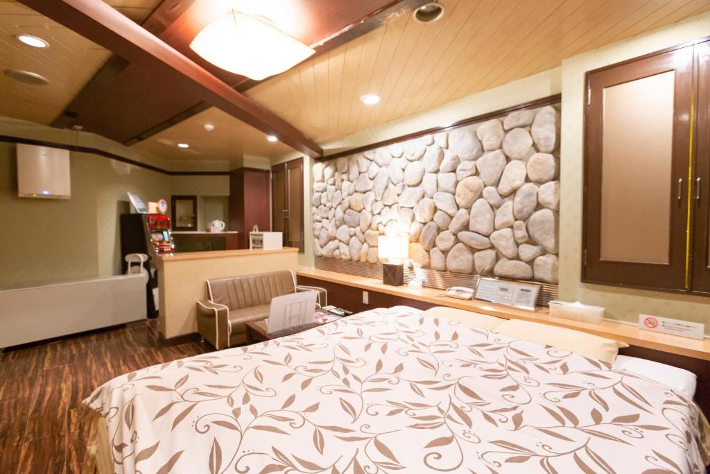 名古屋的住宿－ファインリゾート，一间卧室设有一张床和石墙