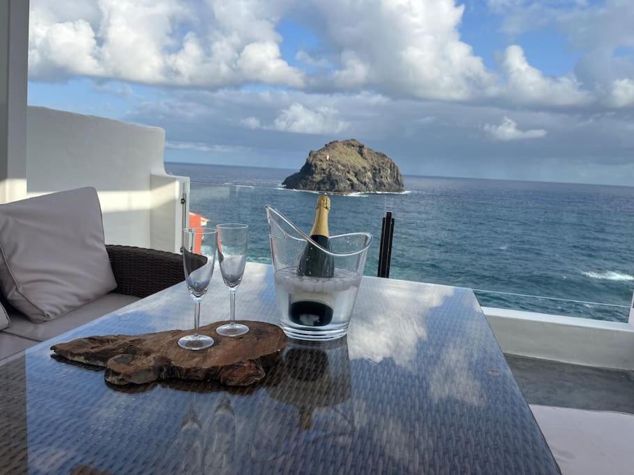 Una mesa con una botella de vino y dos copas. en Vistas impresionantes al mar de Garachico, en Garachico