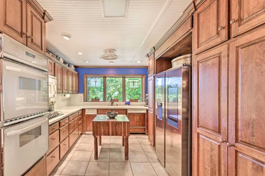 a kitchen with wooden cabinets and a table at Dobson Getaway with Private Pool and Game Room! in Dobson