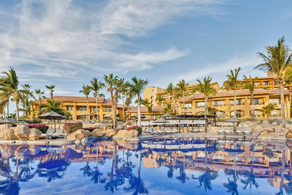 a pool at a resort with palm trees and buildings at Grand Fiesta Americana Los Cabos All Inclusive Golf & Spa in Cabo San Lucas