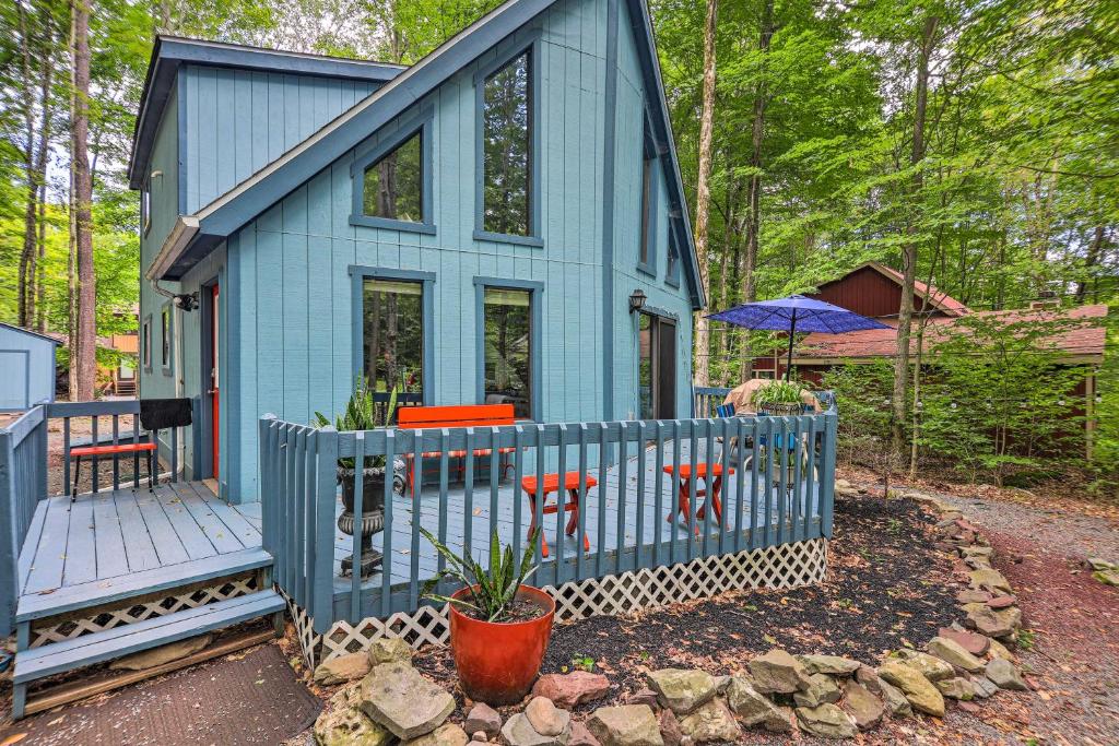 a blue tiny house with a porch and a deck at Colorful Pocono Lake Cabin with Deck and Fire Pit in Pocono Lake