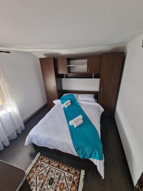 um quarto com uma cama grande e uma cabeceira em madeira em Casa din Deal Isverna Mehedinți em Turtaba