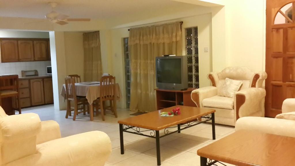 a living room with a tv and a table at JerryDon's Apartment in Saint Georgeʼs