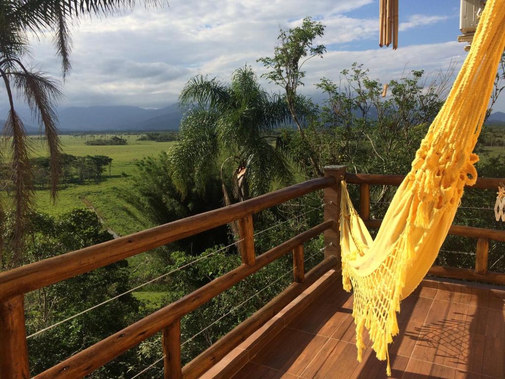 a hammock on a deck with a view of a field at Residencial Paraíso da Gamboa in Garopaba