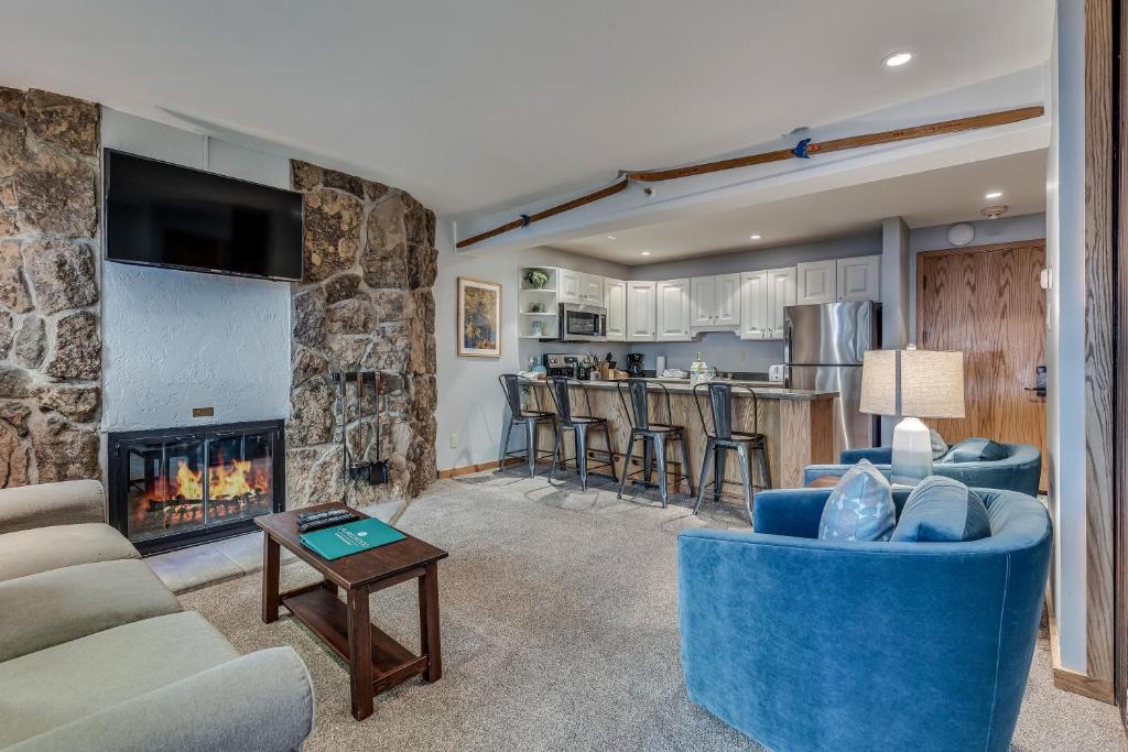 a living room with a blue couch and a fireplace at Laurelwood Condominiums 202 in Snowmass Village