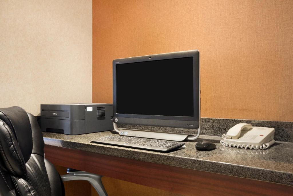 a desk with a computer and a printer on it at Days Inn & Suites by Wyndham Langley in Langley