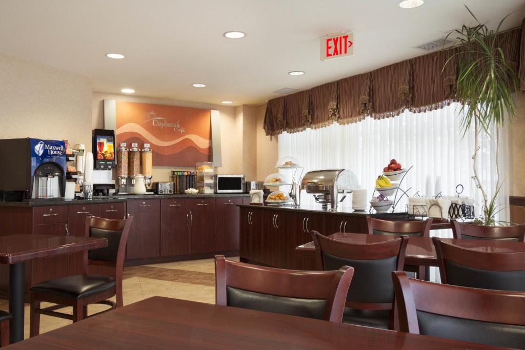 a restaurant with tables and chairs and a bar at Days Inn & Suites by Wyndham Langley in Langley