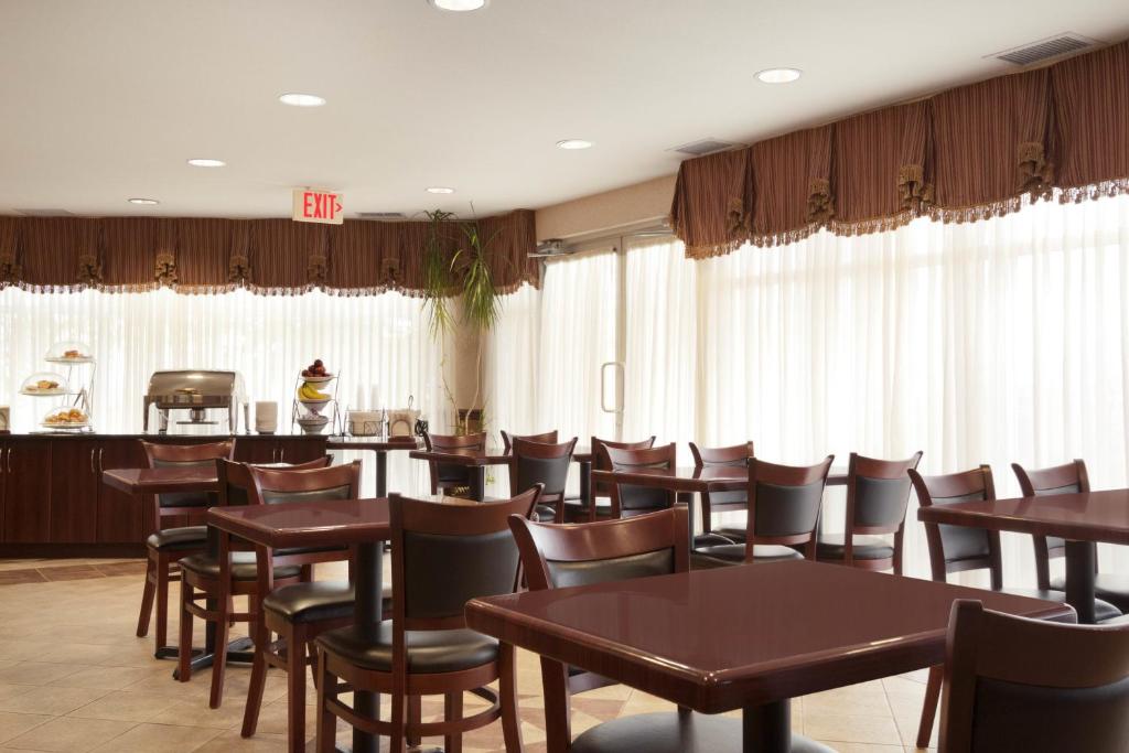 a dining room with wooden tables and chairs at Days Inn & Suites by Wyndham Langley in Langley