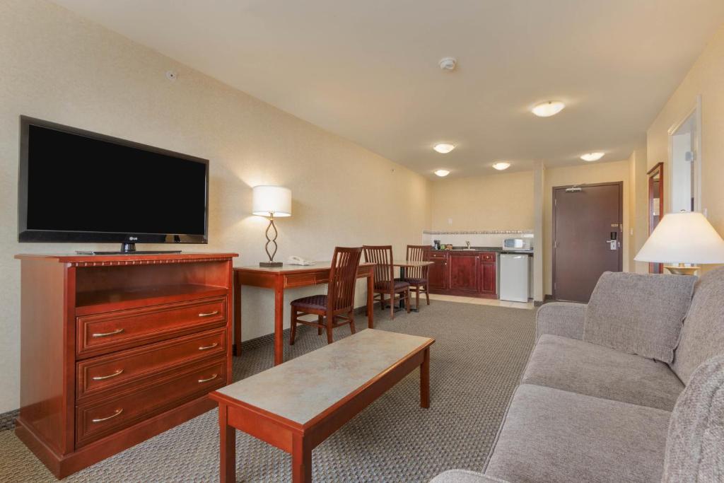 a living room with a couch and a flat screen tv at Days Inn & Suites by Wyndham Langley in Langley