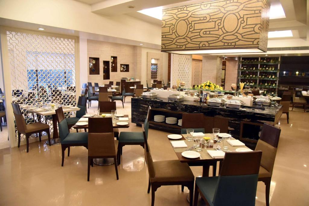 a dining room filled with tables and chairs at Radisson Hotel Varanasi in Varanasi