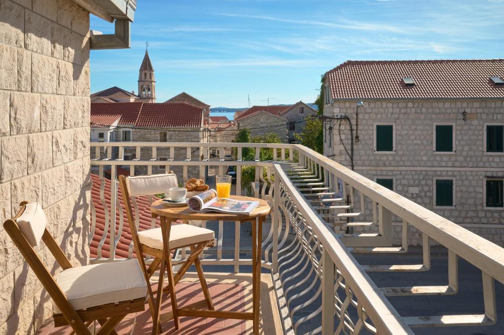 a balcony with a table and chairs on a balcony at Zora Residence in Kaštela