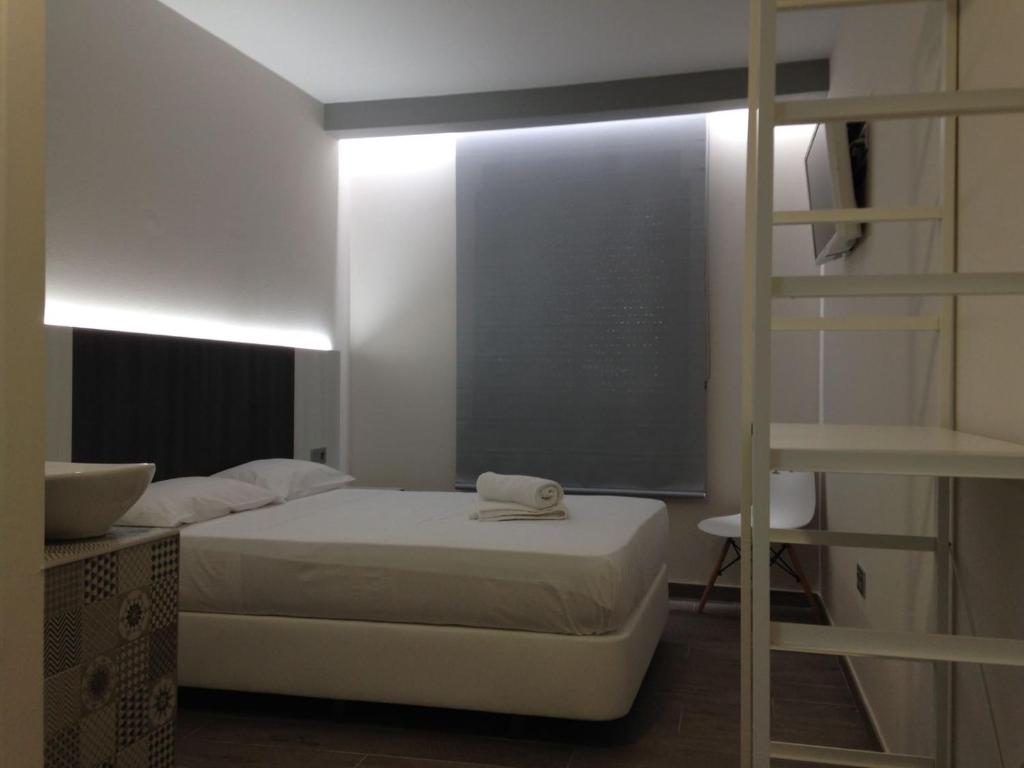 バレンシアにあるHOSTAL LETTO DAL MAREの小さなベッドルーム(ベッド1台、二段ベッド1組付)