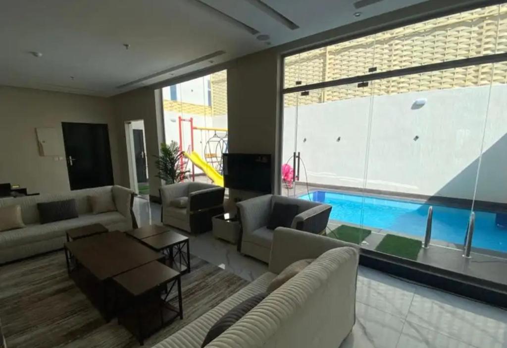 a living room with a pool in the background at فلل اسوار الوسام الفندقية in Taif