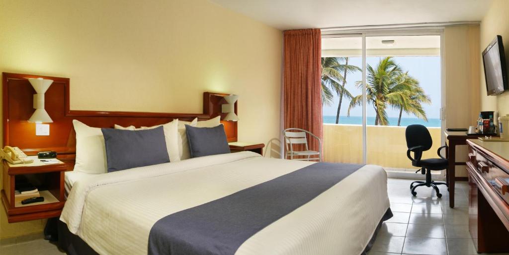 a hotel room with a bed and a view of the ocean at Comfort Inn Veracruz in Veracruz