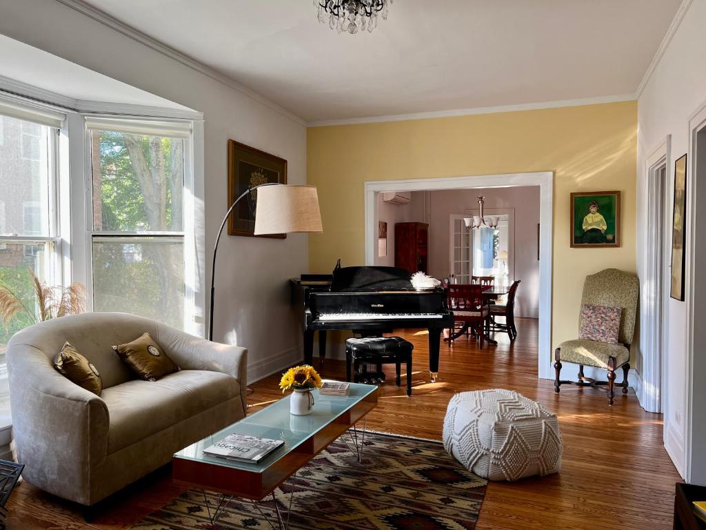 uma sala de estar com um sofá e um piano em Historic Oakpark Home 