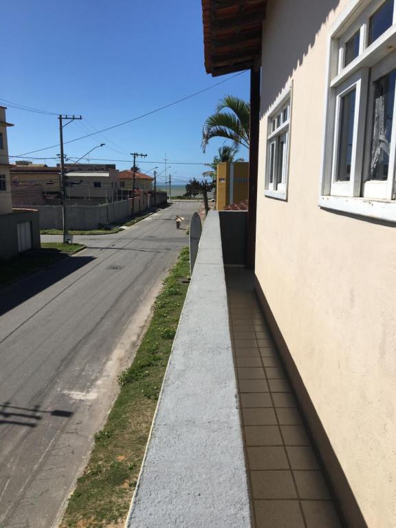 a sidewalk next to a street with a building at Suíte aconchegante na praia in Jacaraípe