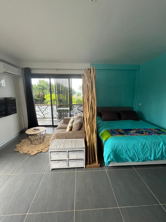 ein Schlafzimmer mit einem Bett und einem großen Fenster in der Unterkunft 2 accomodations -Studio du Manoir -Le Manoir in Punaauia