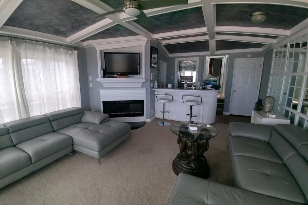 a living room with a couch and a tv at Modern 4bdr Oceanfront home in Virginia Beach
