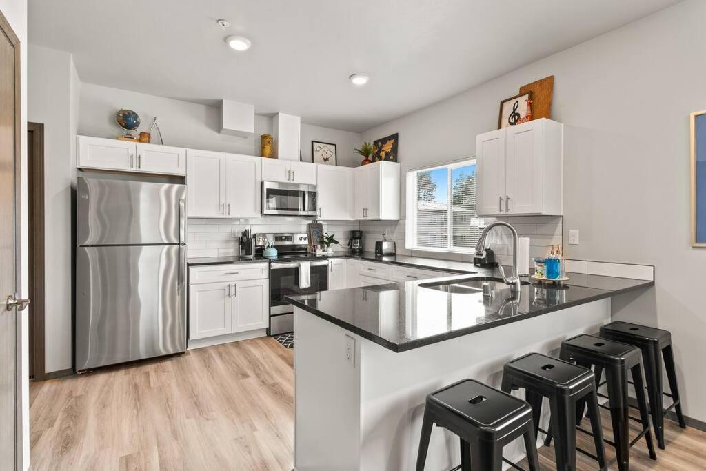 a kitchen with white cabinets and a stainless steel refrigerator at New 2 Bed 2 Bath Near Perry District and DT in Spokane