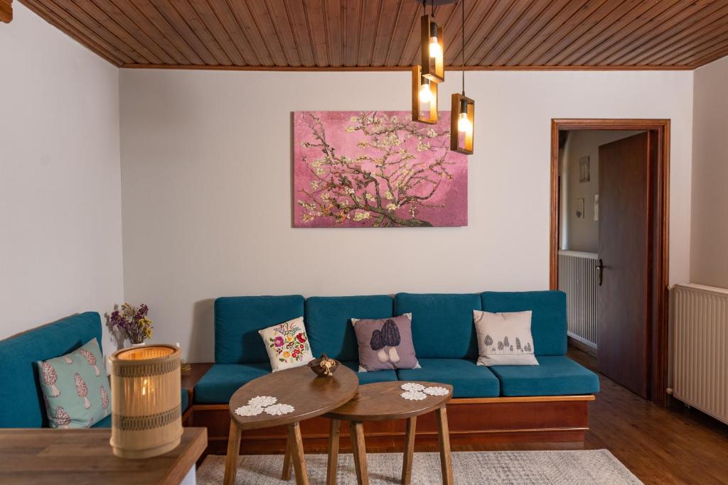 sala de estar con sofá azul y mesa en Μορχέλα, ολόκληρο σπίτι!, en Méga Khoríon