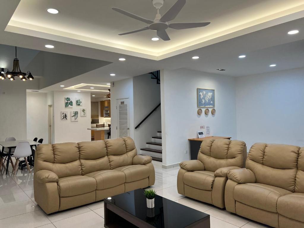 uma sala de estar com 2 sofás e uma ventoinha de tecto em 4 bedrooms (private bathroom) Perdana Hill Villa em Lahad Datu