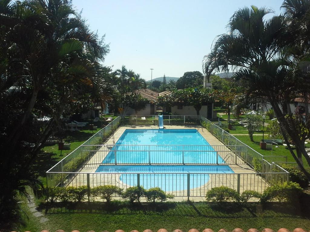 ein leerer Pool in einem Garten mit Palmen in der Unterkunft Apartamento Bangalo Cabo Frio in Cabo Frio