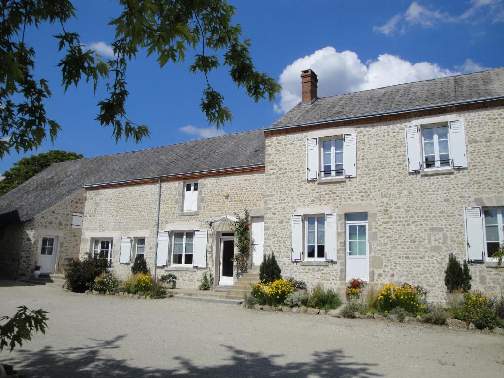 a large brick house with white windows at Ferme de La poterie in Donnery