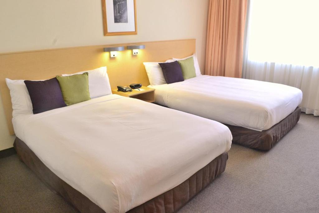 um quarto de hotel com duas camas e uma janela em Distinction Palmerston North Hotel & Conference Centre em Palmerston North