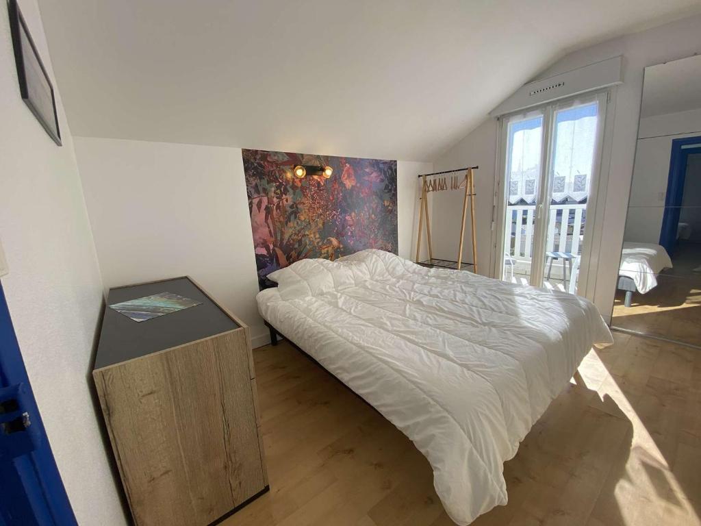 - une chambre avec un lit et une peinture murale dans l'établissement Maison Bénodet, 3 pièces, 4 personnes - FR-1-481-125, à Bénodet