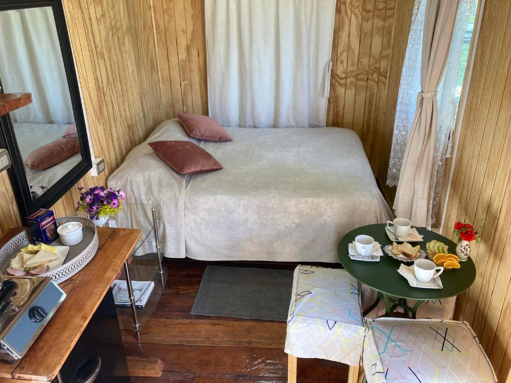 Habitación pequeña con cama y mesa en Cabaña Lemupewen Chillán 6 en Chillán