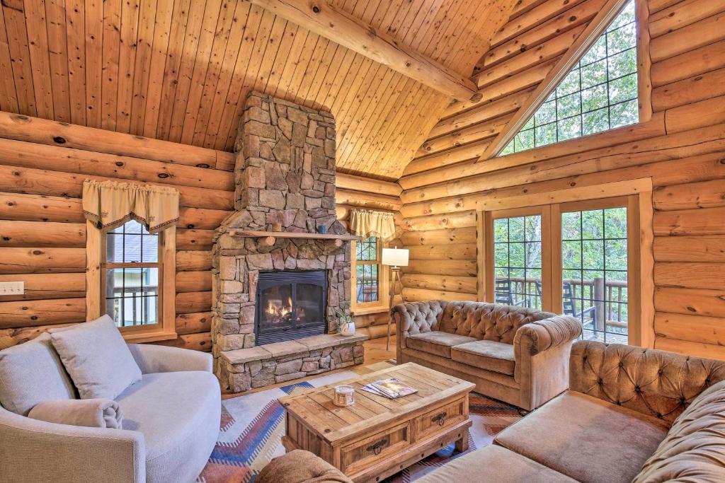 a living room with a fireplace in a log cabin at Splendid Family Cabin with Hot Tub and Grill! in Lake City