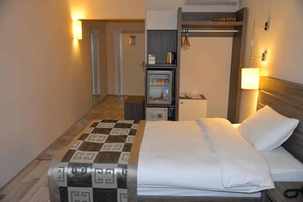 a bedroom with a large bed and a tv at Enar Hotel in Kırıkkale