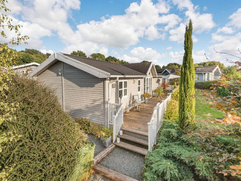 a house with a wooden staircase leading to a yard at Beech Tree Lodge in Willington