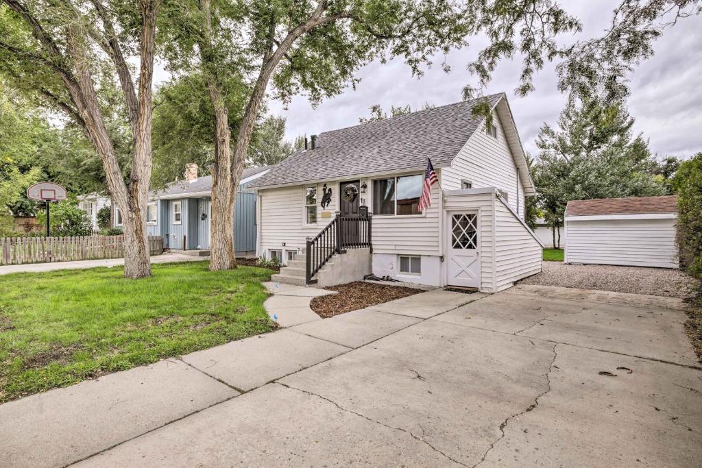 a white house with a flag on it at Historic Casper Retreat with Renovated Yard! in Casper