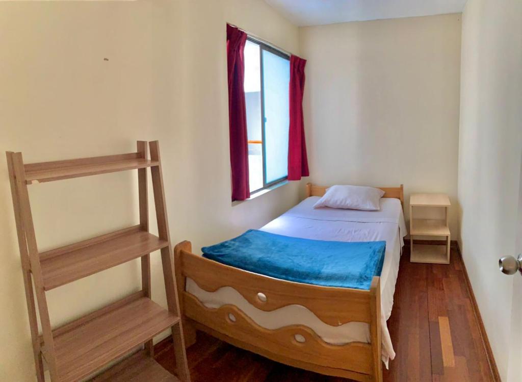 una piccola camera con letto e finestra di Acogedora Habitación en Miraflores a Lima