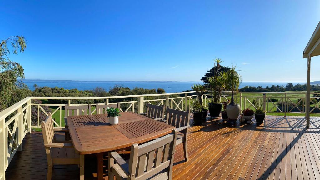 una terraza de madera con mesa y sillas de madera en The Pink House, en Ventnor