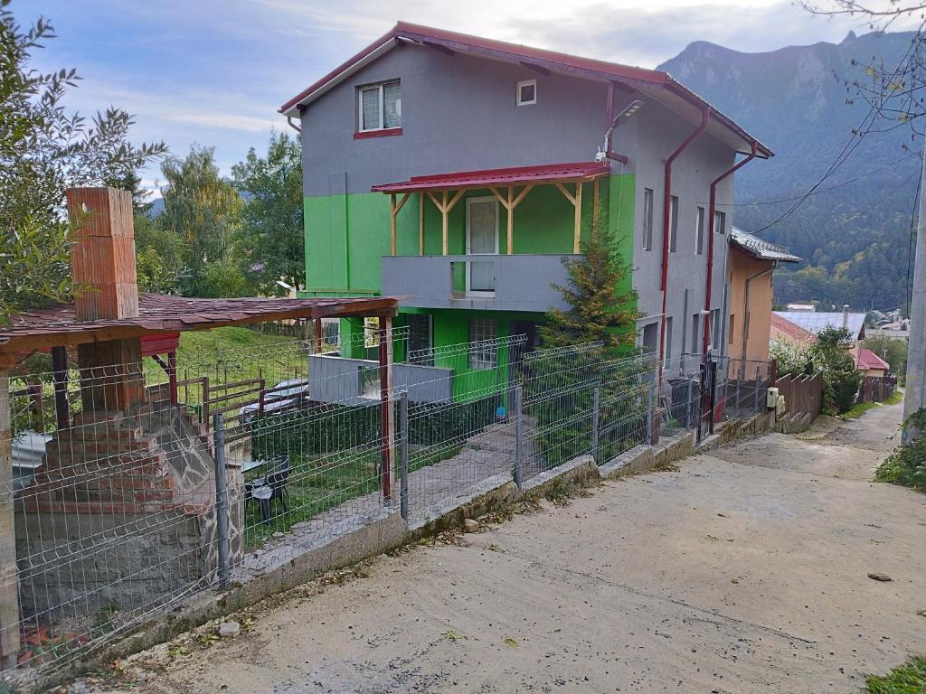 dom z płotem przed nim w obiekcie Vila Cri Cri w mieście Buşteni