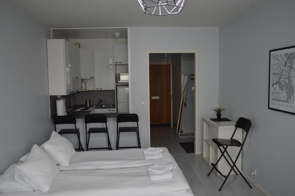 um quarto com uma cama e cadeiras numa cozinha em Polar Haven em Rovaniemi