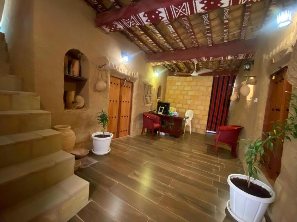 a living room with stairs and a table and chairs at Bait Aljabal Hospitality Inn in Al Ḩamrāʼ