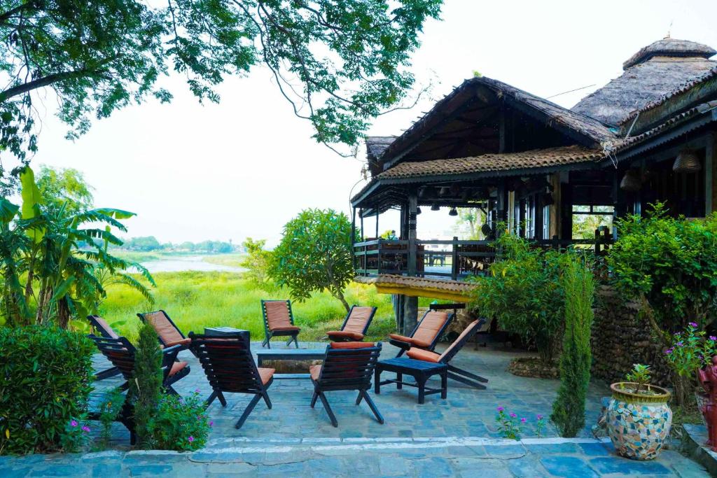 un groupe de chaises et une table devant un bâtiment dans l'établissement Sapana Village Lodge, à Sauraha