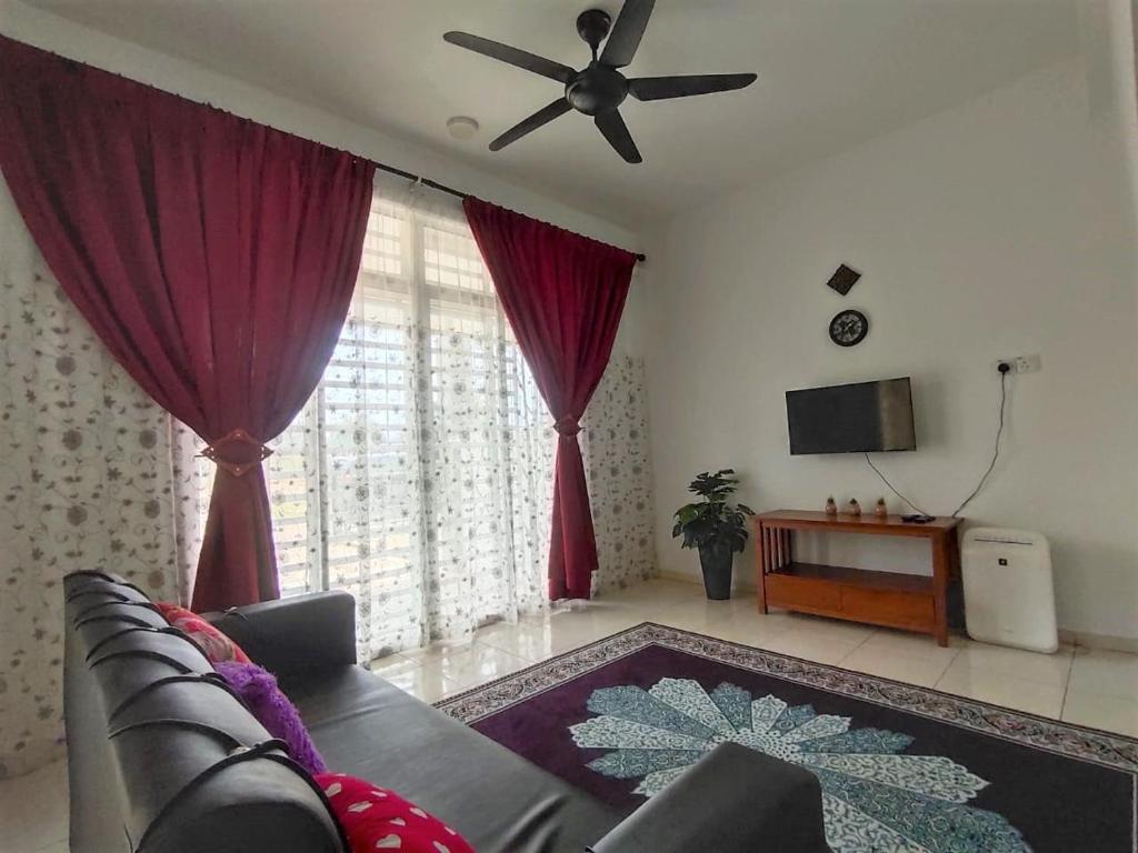 uma sala de estar com um sofá e uma ventoinha de tecto em HOMESTAY HAIKALHAIDAR em Rantau Panjang