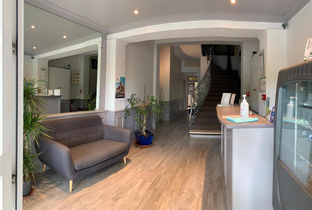 - un salon avec un canapé et un escalier dans l'établissement Logis Hotel du Midi, à Salon-de-Provence