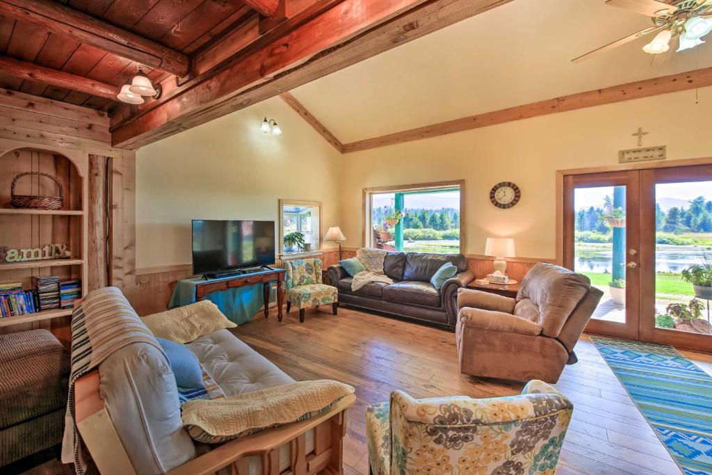 a living room with couches and a tv at Family Home with Stunning River and Mountain View in Priest River