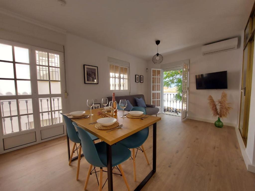 uma sala de jantar com uma mesa e cadeiras azuis em Casa del Arco em Olvera